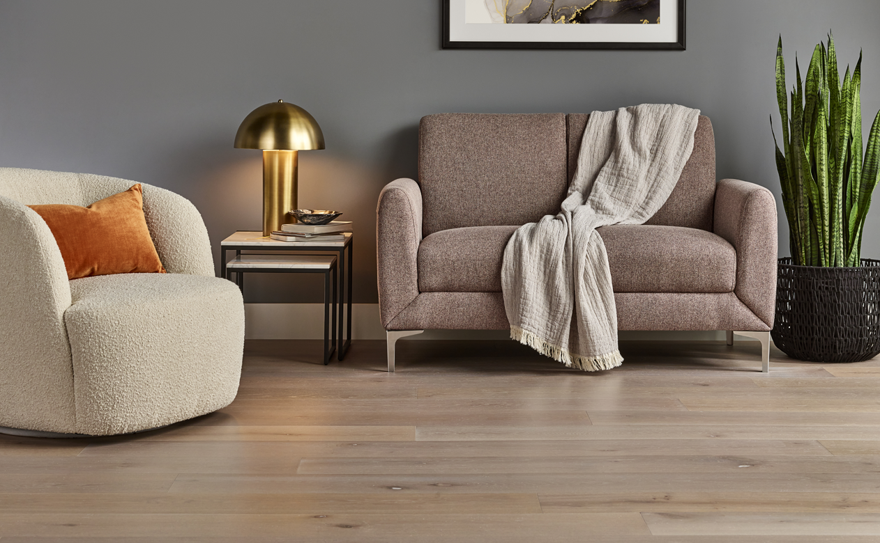 Light hardwood floors in grey wall living room with beige furnishings 